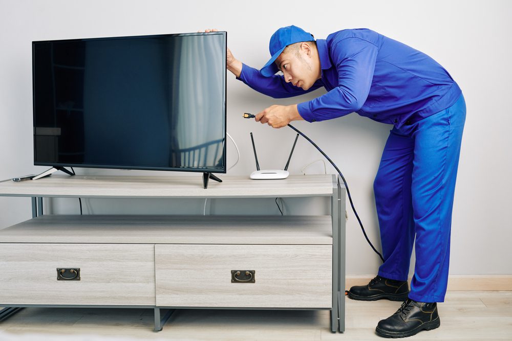 Young Electrician Fixing television